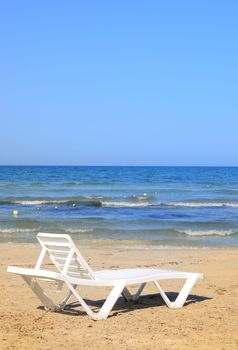 deckchairs on the beach under blue sky