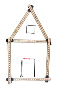 House made of a folding ruler and some tools isolated on a white background