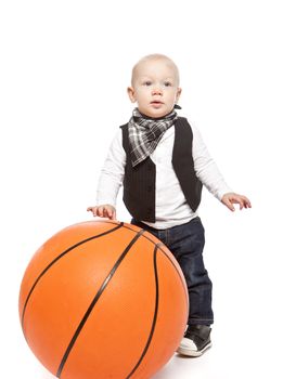 Fashion boy playing whit a huge basketball against a white background