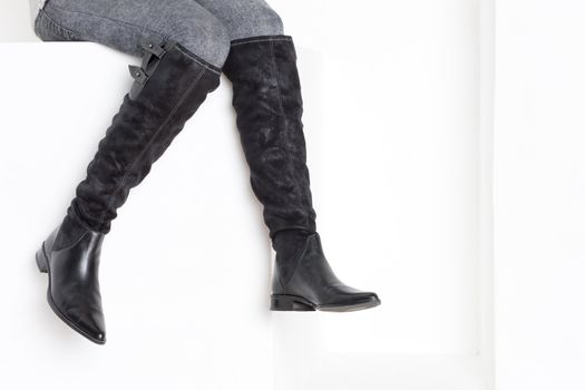 detail of sitting woman wearing fashionable boots