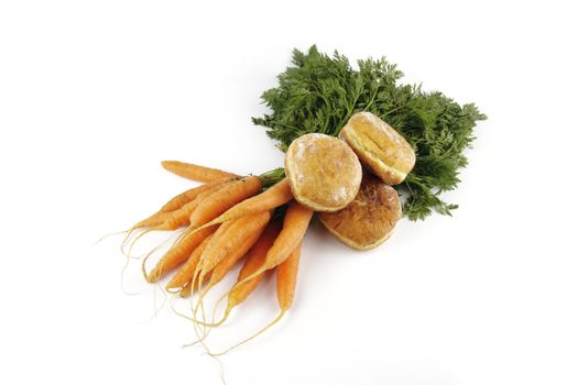 Contradiction between healthy food and junk food using bunch of carrots and doughnut on a reflective white background 