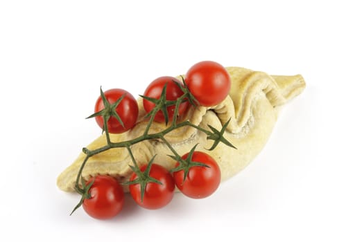 Contradiction between healthy food and junk food using tomatoes and a pasty on a reflective white background 