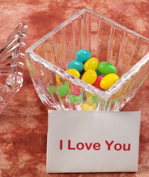 A bowl of candy and a note saying I love you, with focus on the candy