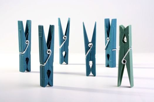 Dark blue plastic clothespins are placed on a table.