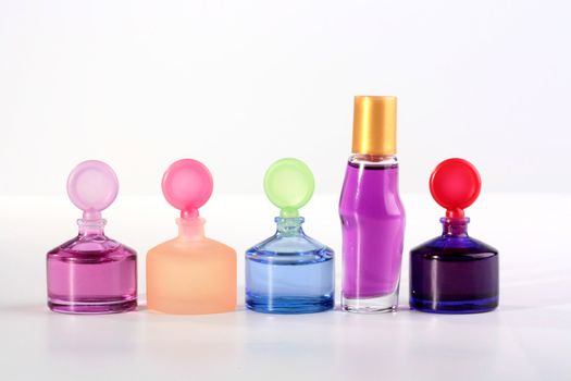 Colour small small bottles with cosmetics for care of a skin on a white background.