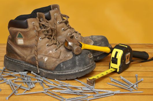 A pair of construction grade work boots with some other tools.