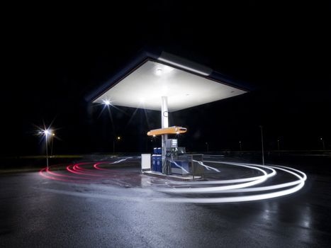 Petrol station at night with traffic in movement