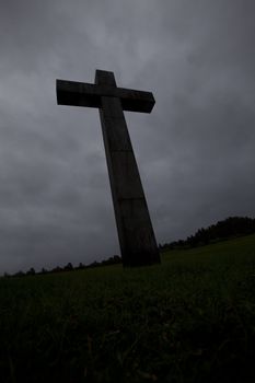 Dark cross against a dramatic grey sky