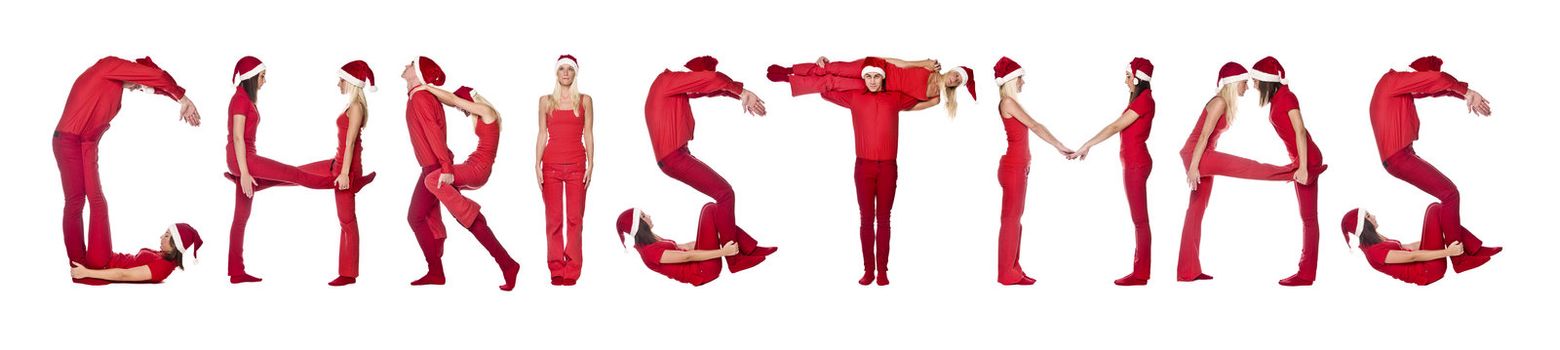 Group of red dressed people forming the word 'Christmas', isolated on white.
