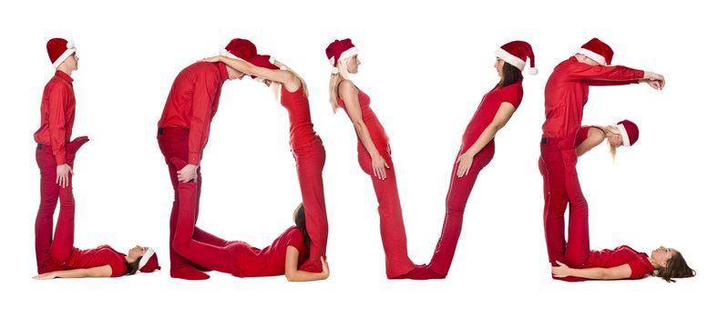 Group of red dressed people forming the word 'LOVE', isolated on white.