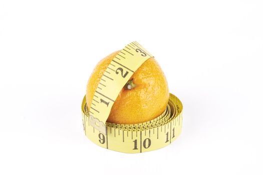 Small single satsuma with tape measure wrapped around on a reflective white background