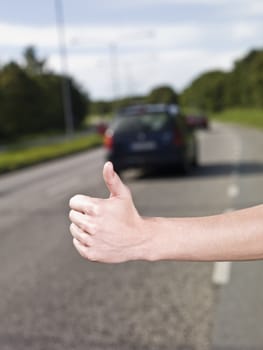 A young man hitchiking on the road