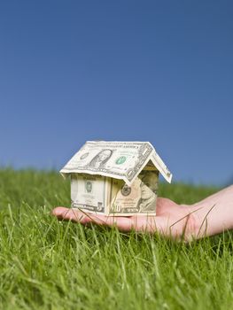 Man holding a dollar house outside