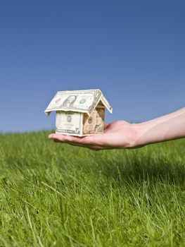 Man holding a dollar house outside