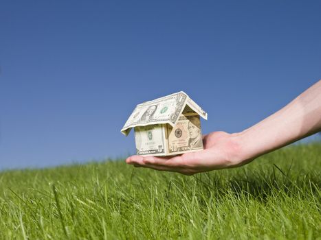 Man holding a dollar house outside