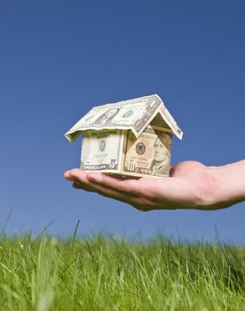 Man holding a dollar house outside