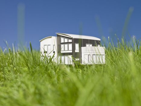 A miniature house outside in the sun.