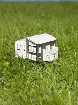 A miniature house outside in the sun.