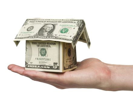 Man holding a small house built out of dollar bills