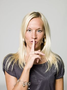 Portrait of a woman shushing