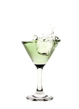 Green liquid splashing in a martini glass.