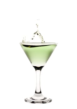 Green liquid splashing in a martini glass.