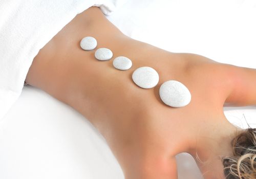 young woman in a spa having hot stones treatment
