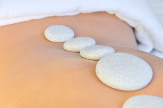 young woman in a spa having hot stones treatment 