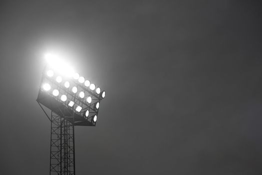 Stadium spotlights lit at night.