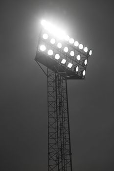Stadium spotlights lit at night.