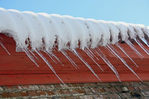 Icicle on a background of a brick wall.