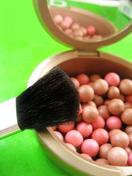 Many brown and pink blusher and brush, focus on brush