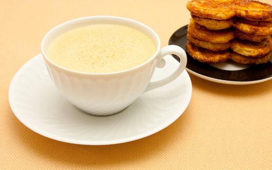 Closeup of coffee with milk in white cup and a palmier pastry