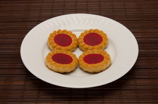A plate of cookies on dark brown background