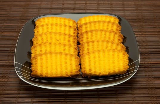 A plate of cookies on dark brown background