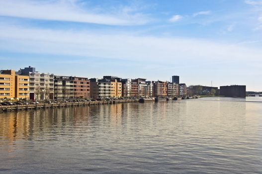 Modern architecture in Amsterdam. Island of Borneo. Modern housing is reflected in the water against the blue sky.