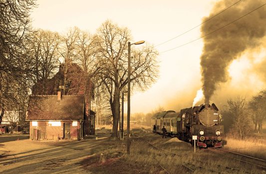 Old retro steam train stopped at the small station
