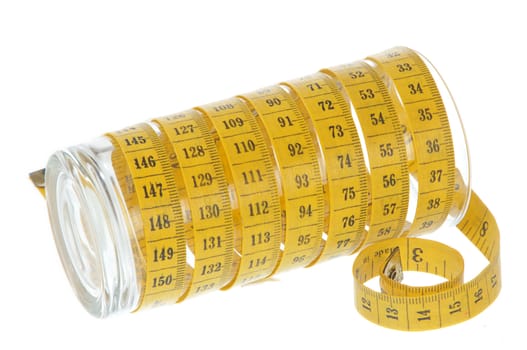 yellow measuring tape around empty glass on white