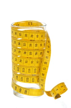 yellow measuring tape around empty glass on white