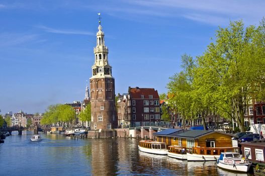 Classical Amsterdam view. Boat floats on the channel on the background of bridge. Urban scene.