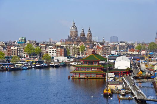 Classical Amsterdam view. Boat floats on the channel on the background of bridge. Urban scene.