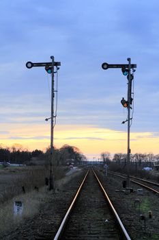 Old railway semaphores and rails against the dramatic sky
