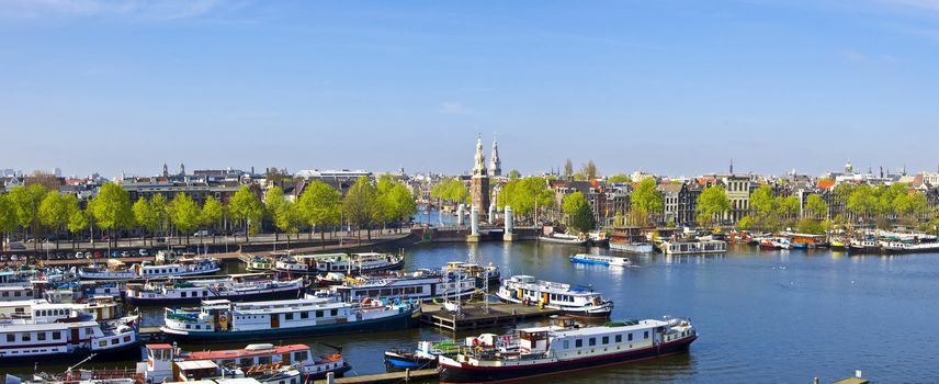 Classical Amsterdam view. Boat floats on the channel on the background of bridge. Urban scene.