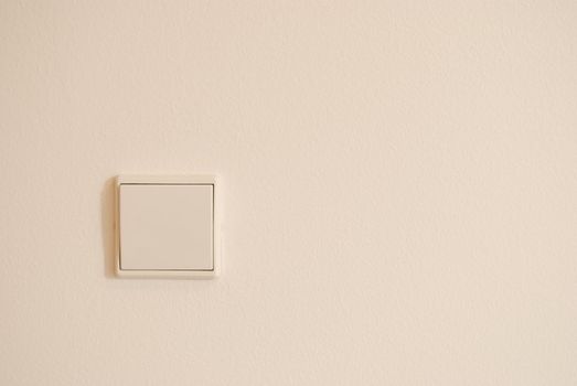 white light switch against white wall (plenty copy-space)