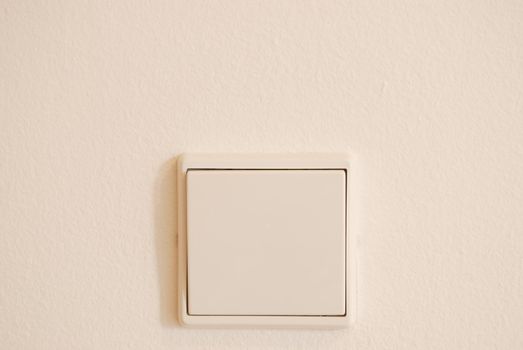 white light switch against white wall (plenty copy-space)