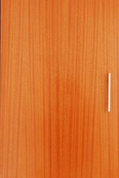 close up of a wooden wardrobe door with a metal handle