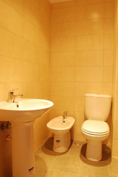 photo of a white and small bathroom interior (golden tiles)