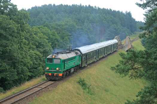Passenger train passing through polish countryside
