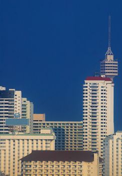 Tower and skyscrapers with vibrant blue sky.