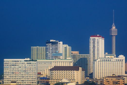 Tower and skyscrapers with vibrant blue sky.